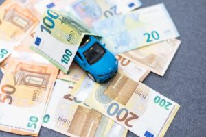 A blue toy car surrounded by various denominations of Euro banknotes.